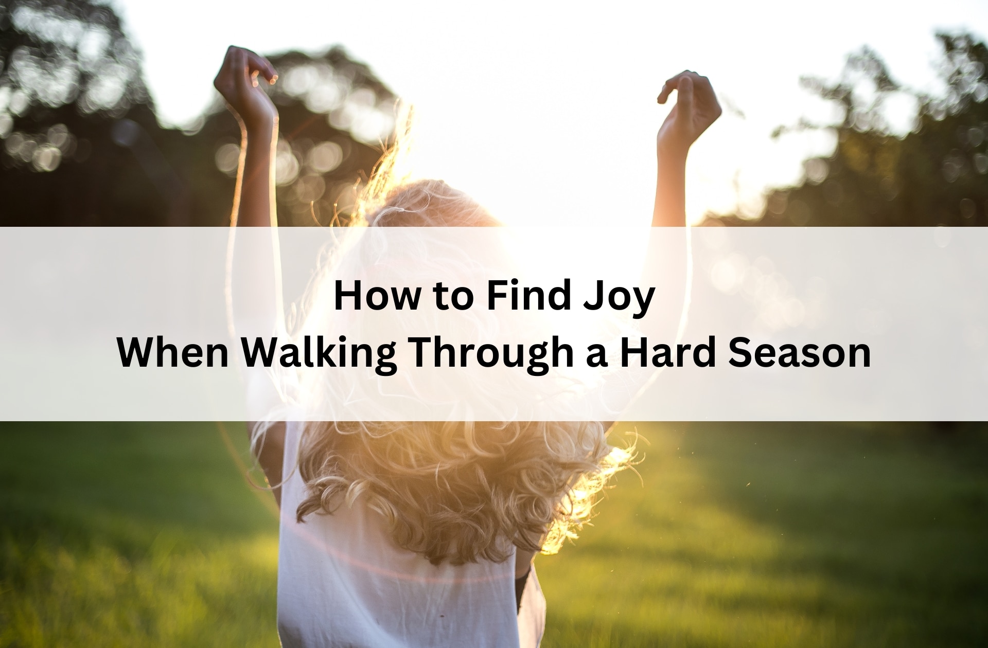 Girl stands in sunlight with arms raised in joy, surrounded by nature, with overlay text: “How to Find Joy When Walking Through a Hard Season.”