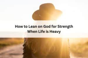 Person in a hat standing in sunlight on a rural path; overlay text reads “How to Lean on God for Strength When Life is Heavy.”