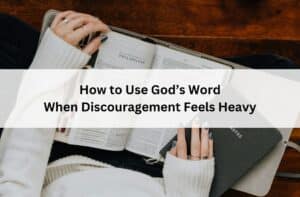 Hands holding an open Bible and notebook; overlay text reads “How to Use God’s Word When Discouragement Feels Heavy.”